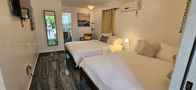 bedroom with a wall mounted AC and dark hardwood / wood-style floors