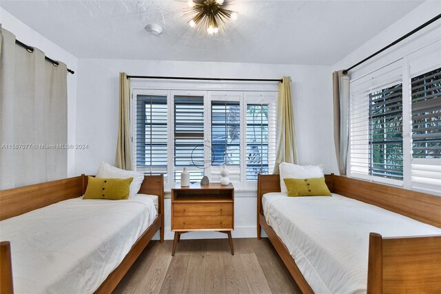 bedroom with multiple windows and hardwood / wood-style floors