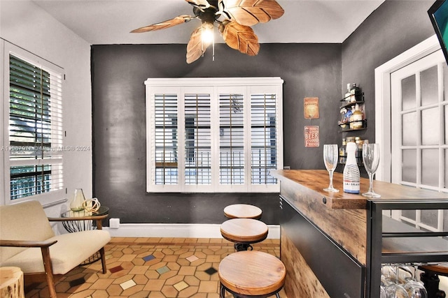 bar with ceiling fan and tile patterned flooring