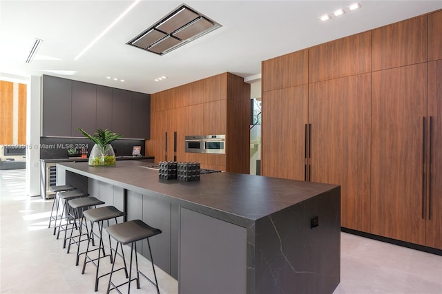 kitchen with a kitchen breakfast bar, wine cooler, oven, and a spacious island