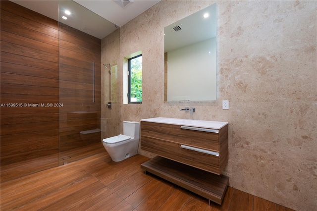 bathroom featuring walk in shower, toilet, vanity, and hardwood / wood-style flooring