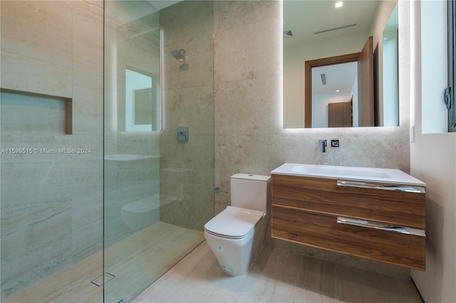 bathroom featuring tiled shower, toilet, tile walls, and vanity