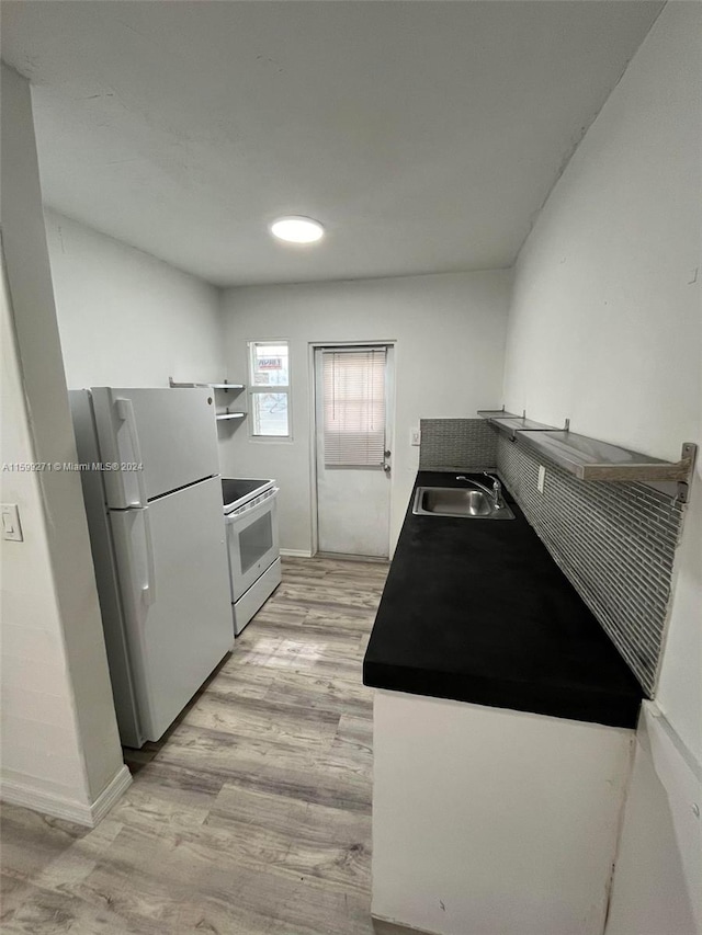 kitchen featuring sink, white appliances, and light hardwood / wood-style floors