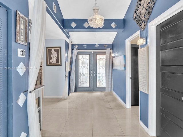 entrance foyer featuring a chandelier, light tile patterned floors, and french doors