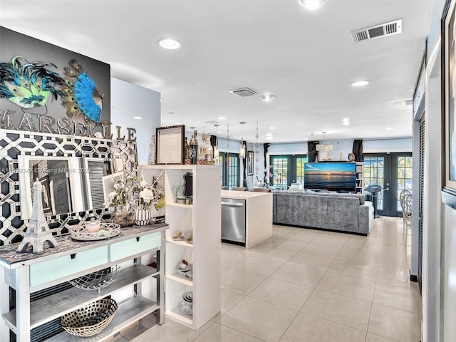 interior space featuring stainless steel dishwasher, a kitchen island, and light tile patterned floors