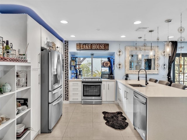 kitchen featuring decorative light fixtures, stainless steel appliances, white cabinetry, and sink