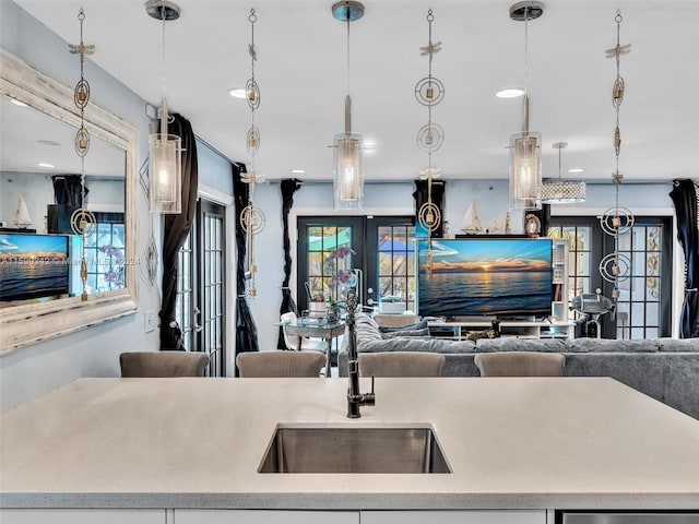 kitchen featuring french doors, pendant lighting, and sink