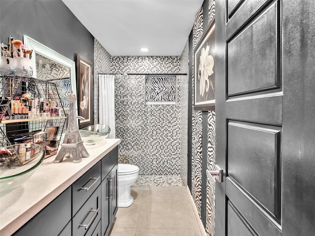 bathroom featuring tile patterned floors, toilet, vanity, and walk in shower