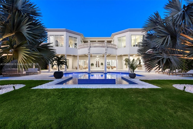 rear view of house with a lawn and a patio