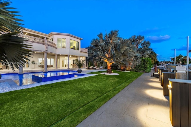 pool at dusk with a lawn