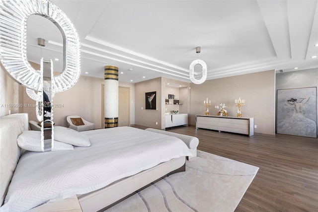 bedroom with a raised ceiling and dark hardwood / wood-style floors