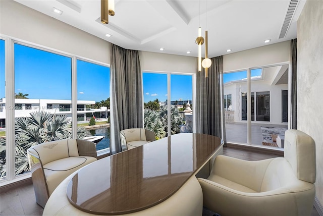 dining room featuring beamed ceiling, hardwood / wood-style floors, a water view, and coffered ceiling