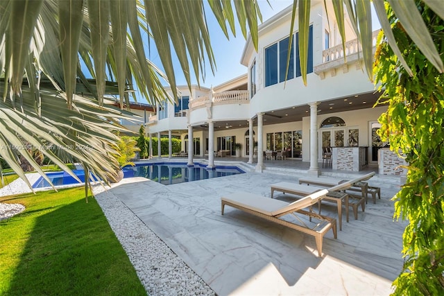 rear view of property featuring a patio and a balcony