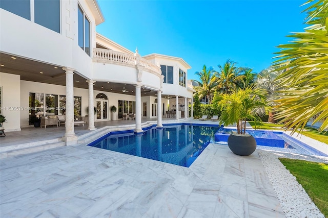 view of pool with a jacuzzi, a patio, and ceiling fan