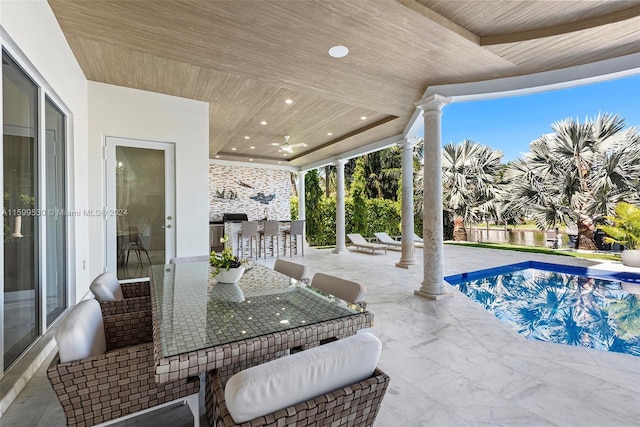 view of pool with exterior bar, a patio, and ceiling fan