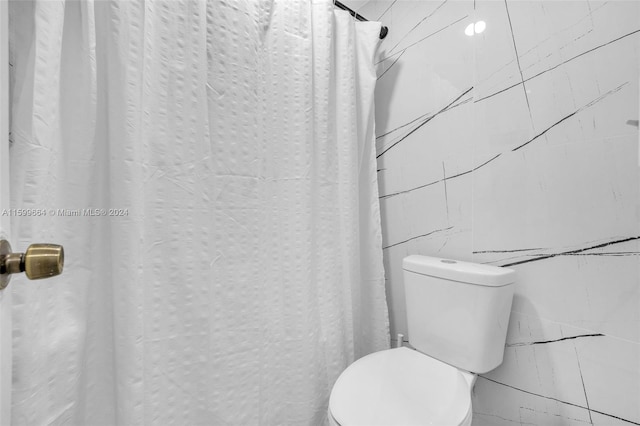 bathroom featuring curtained shower and toilet