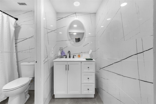 bathroom with tile walls, walk in shower, toilet, and vanity