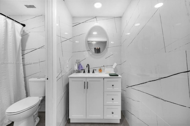 bathroom featuring vanity, toilet, tile walls, and curtained shower