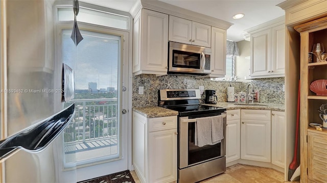 kitchen featuring decorative backsplash, sink, light stone counters, and stainless steel appliances