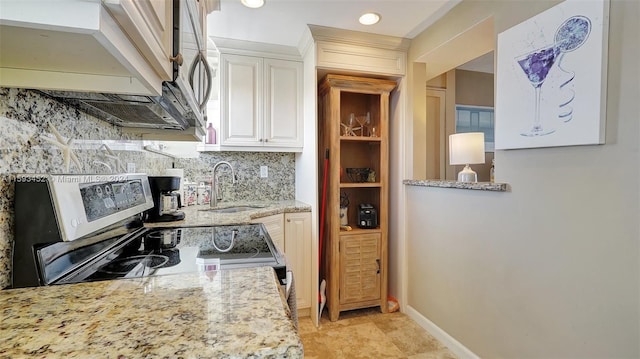 kitchen featuring white cabinets, electric stove, sink, tasteful backsplash, and light stone counters