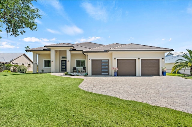 prairie-style house featuring a garage and a front lawn