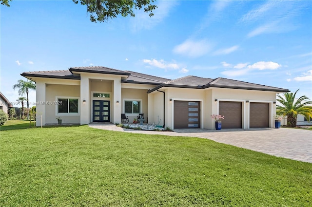 prairie-style home with a garage, french doors, and a front lawn