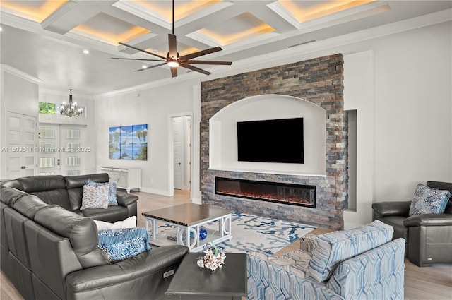 living room featuring crown molding, beam ceiling, coffered ceiling, a notable chandelier, and light hardwood / wood-style floors