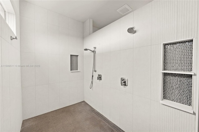 bathroom with tiled shower