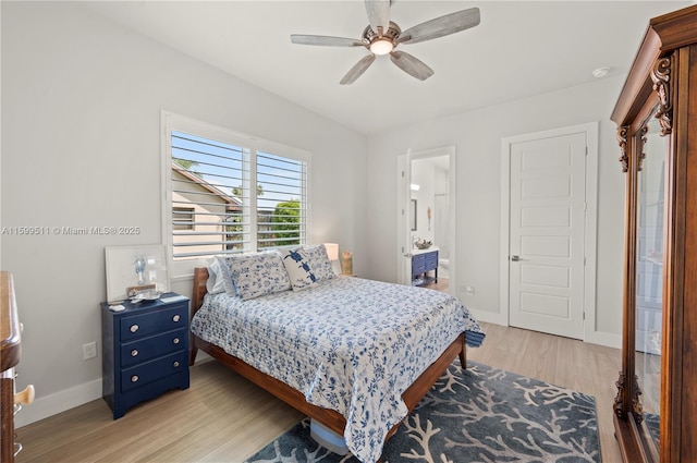 bedroom featuring ceiling fan, ensuite bath, and light hardwood / wood-style flooring