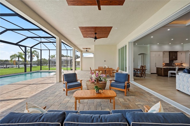 view of patio featuring an outdoor living space, a lanai, and ceiling fan