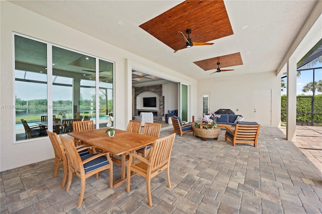 exterior space featuring an outdoor living space with a fireplace and ceiling fan