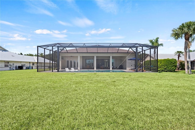 back of property with glass enclosure, a pool, and a yard