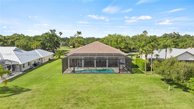 back of property featuring glass enclosure and a lawn