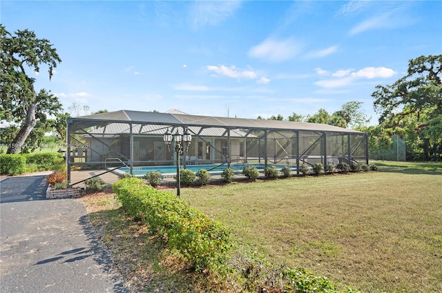 view of swimming pool featuring a lanai and a yard