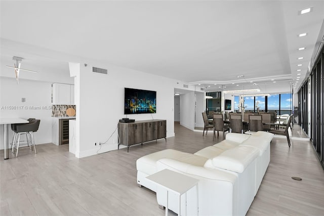 living room with beverage cooler and light hardwood / wood-style floors