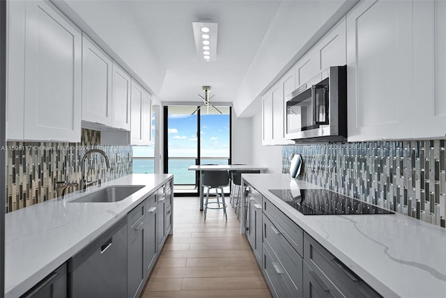 9455 Collins Ave Unit 809, Surfside, FL 33154 - kitchen featuring gray cabinetry, appliances with stainless steel finishes, decorative backsplash, and a sink