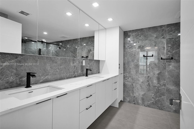 bathroom with tile flooring, double sink, tile walls, walk in shower, and large vanity