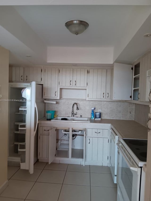 kitchen featuring decorative backsplash, white appliances, and white cabinets