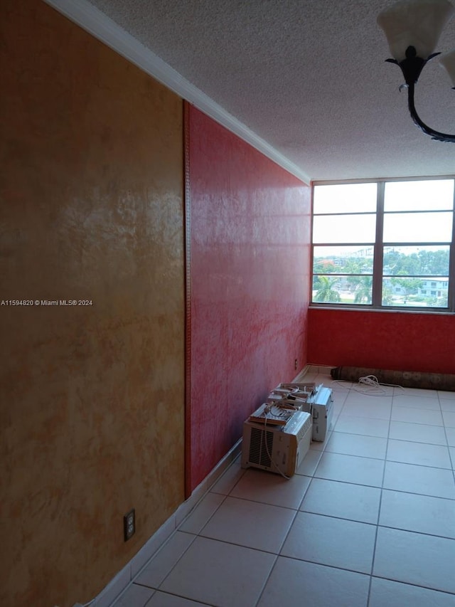 tiled spare room with crown molding and a textured ceiling