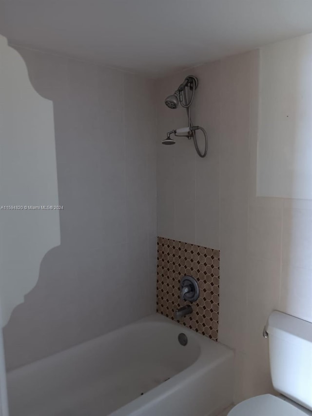 bathroom with tile walls and toilet