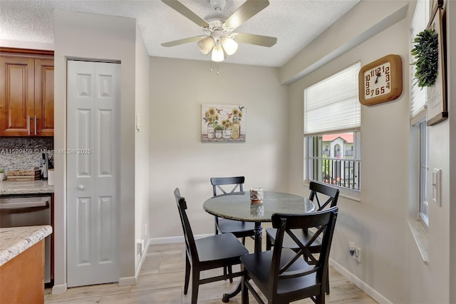 dining space featuring ceiling fan, a textured ceiling, and light wood-type flooring