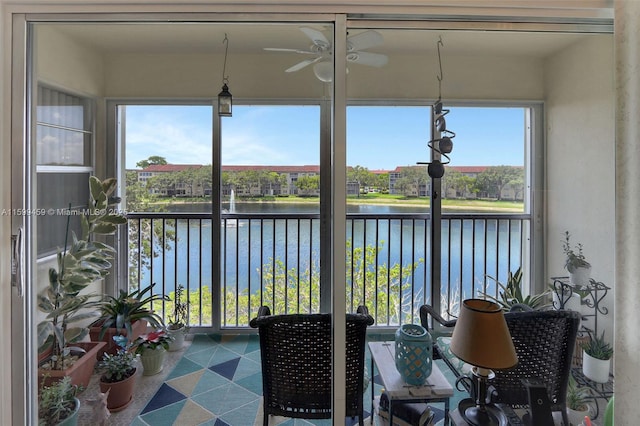 sunroom featuring a water view, plenty of natural light, and ceiling fan