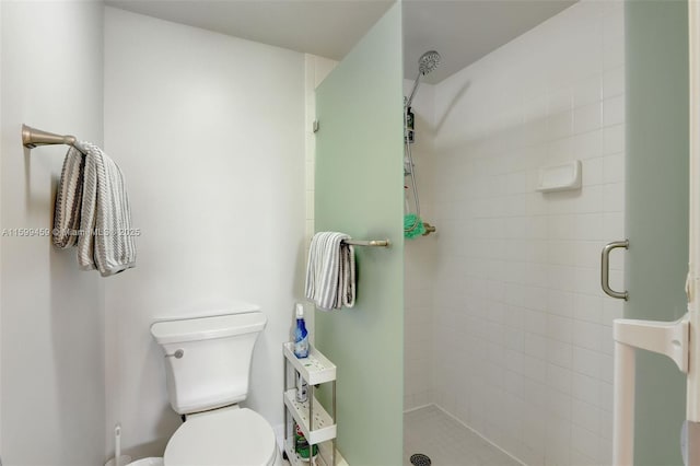 bathroom featuring a tile shower and toilet