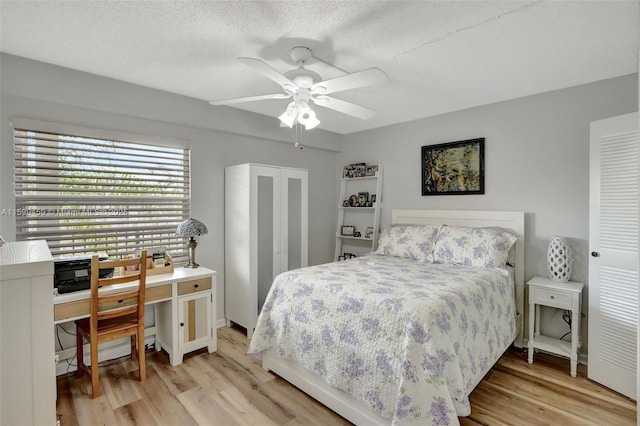 bedroom featuring a textured ceiling, ceiling fan, and light hardwood / wood-style flooring