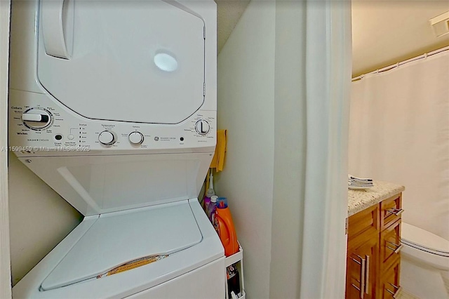 clothes washing area with stacked washer and clothes dryer