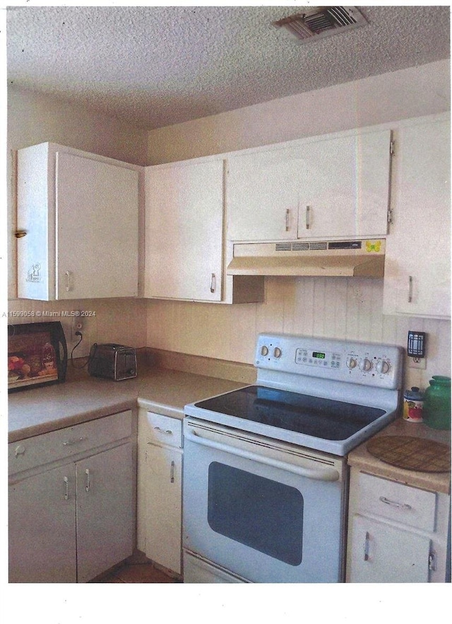 kitchen with white cabinetry, white electric stove, and a textured ceiling