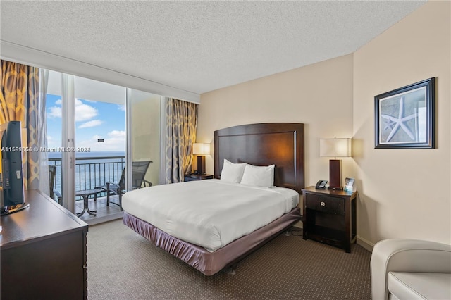 carpeted bedroom with a textured ceiling, floor to ceiling windows, baseboards, and access to exterior