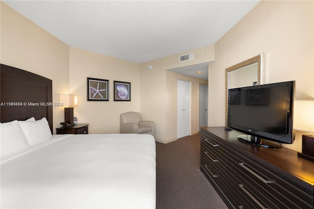 bedroom with visible vents, a textured ceiling, and carpet flooring