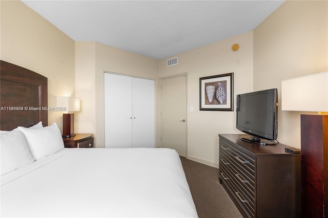 bedroom featuring baseboards, visible vents, a textured ceiling, carpet flooring, and a closet