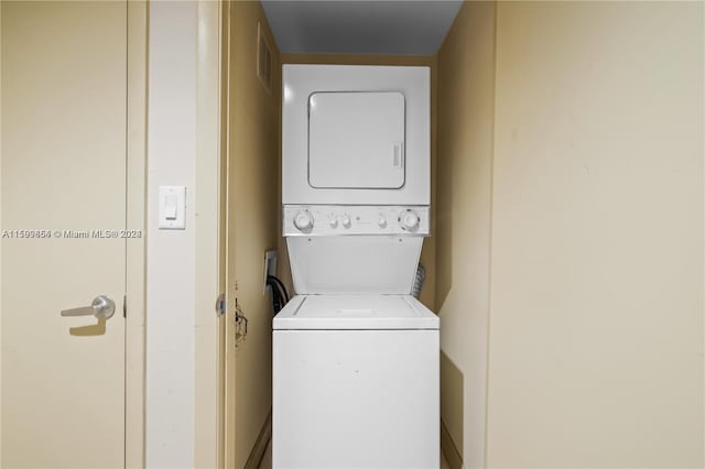 washroom featuring stacked washing maching and dryer, visible vents, and laundry area